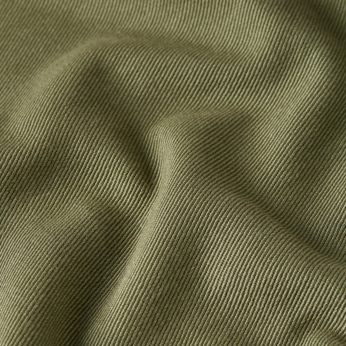 Texture of high-waisted chino fatigue pants in a soft, olive green color.