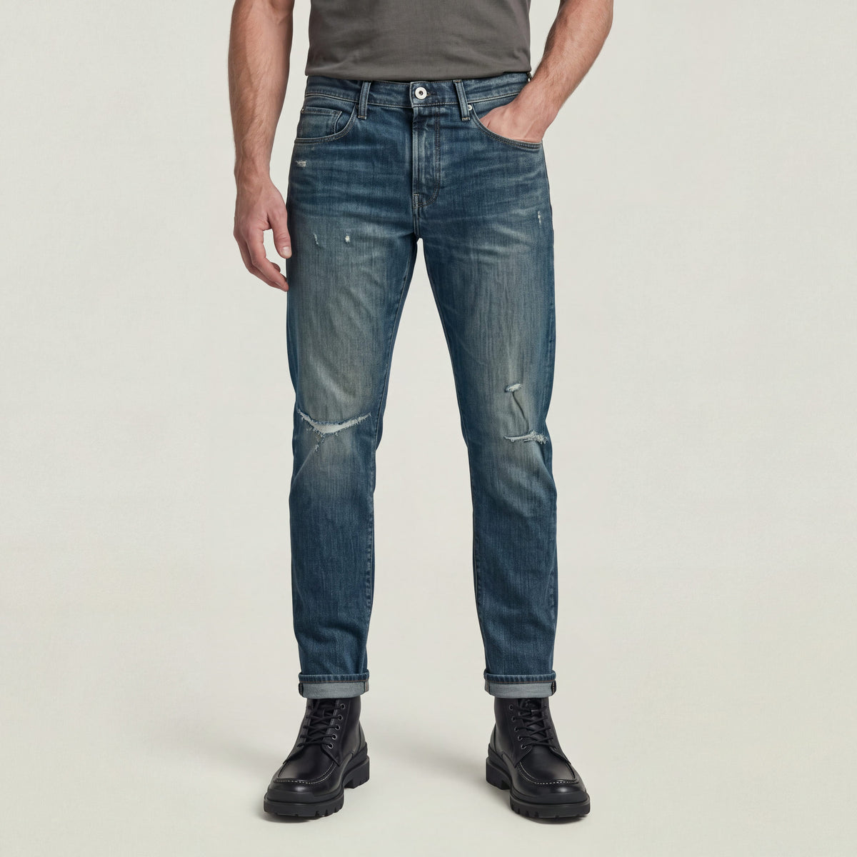 Hombre usando 3301 slim fit jeans de denim greencast con acabado único y botines negros.