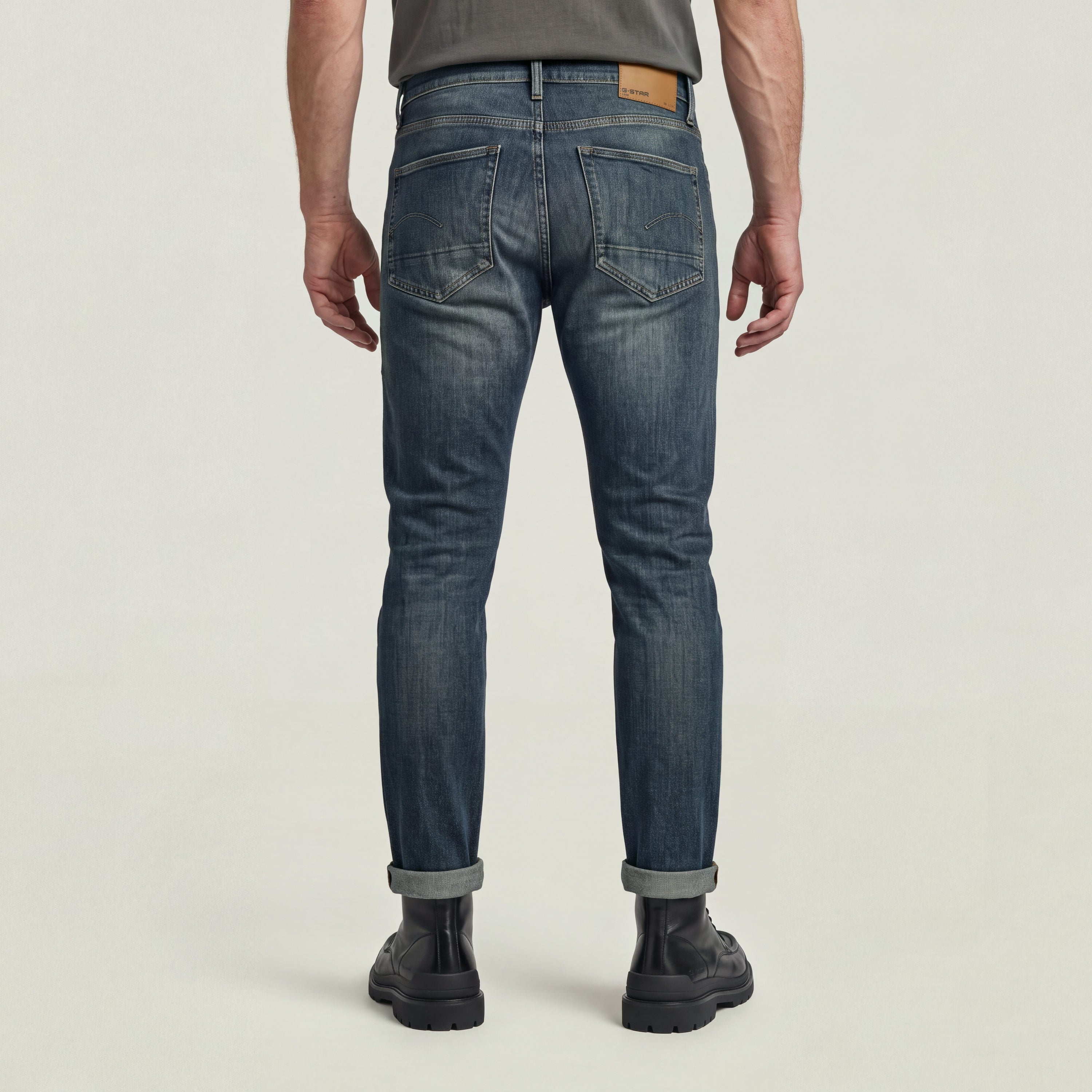 Hombre usando 3301 slim fit jeans desde atrás con detalles de costura y etiqueta G-STAR en la cintura.