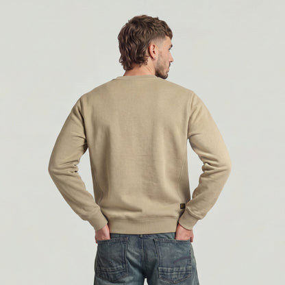 Hombre de espaldas usando un premium core sweater de cuello redondo en color beige.