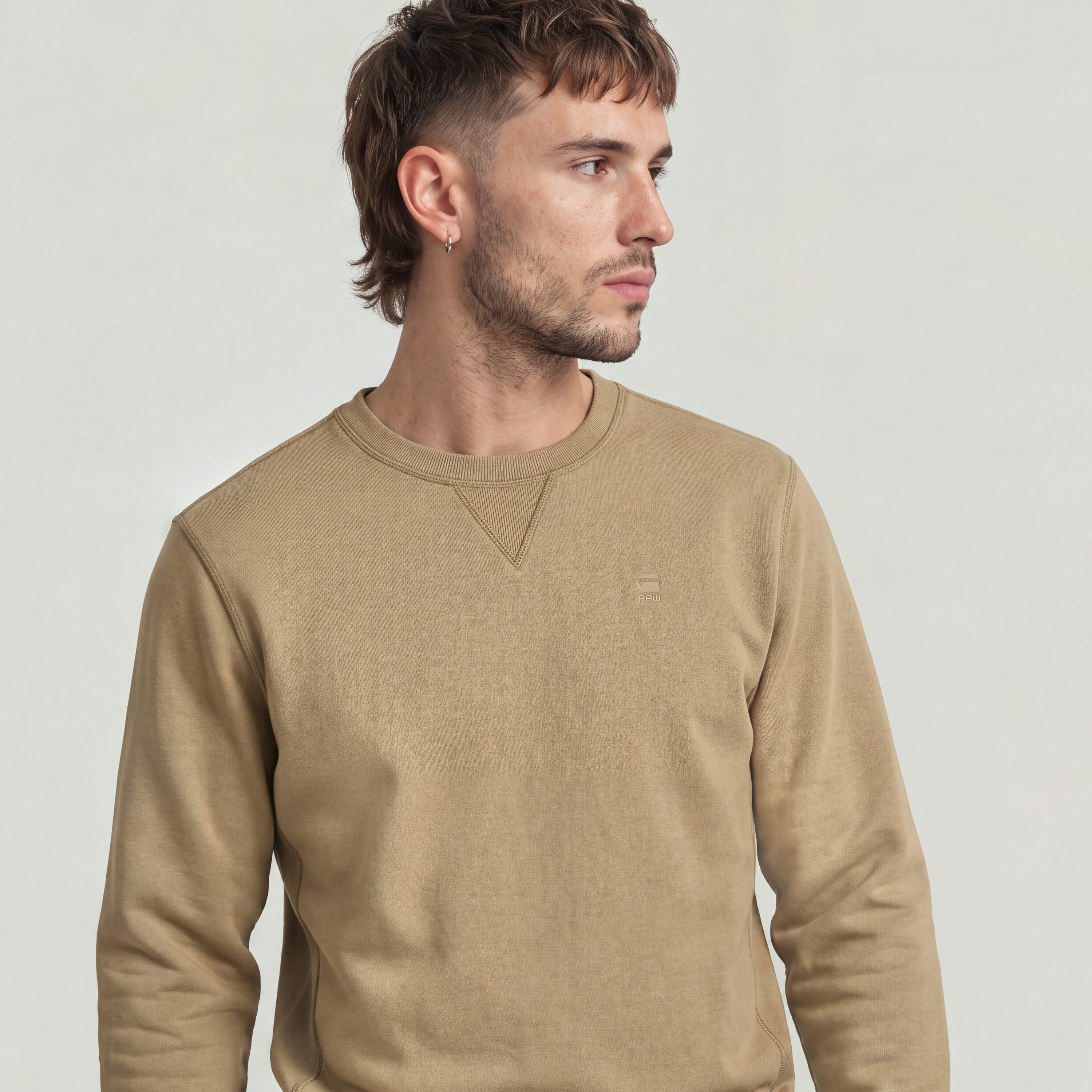 premium core sweater displayed on a man, featuring a round neck and triangular insert detail.