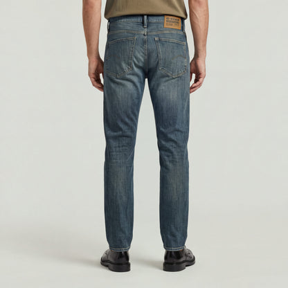 Hombre usando Mosa straight jeans, vista trasera mostrando detalles de diseño y etiqueta.