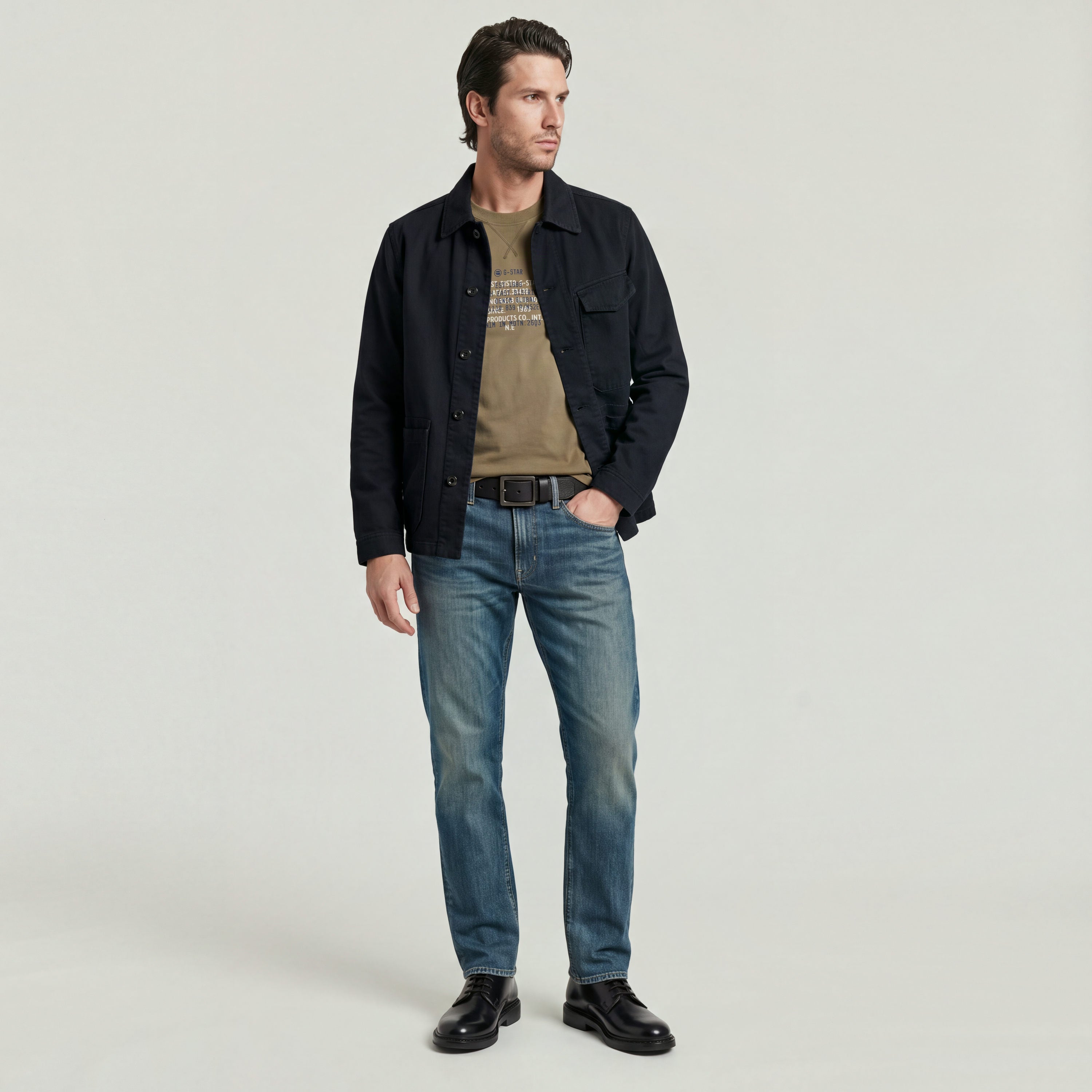 Hombre vistiendo Mosa straight jeans con chaqueta oscuros y camiseta, posando para la cámara.