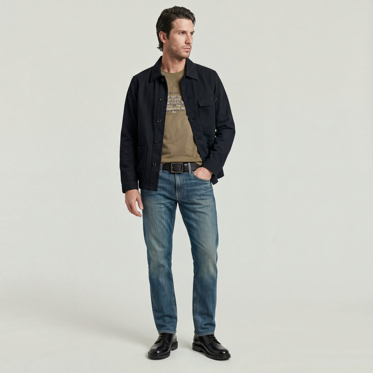 Hombre vistiendo Mosa straight jeans con chaqueta oscuros y camiseta, posando para la cámara.
