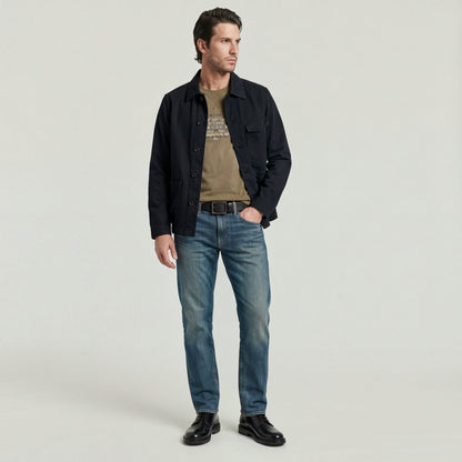 Hombre vistiendo Mosa straight jeans con chaqueta oscuros y camiseta, posando para la cámara.