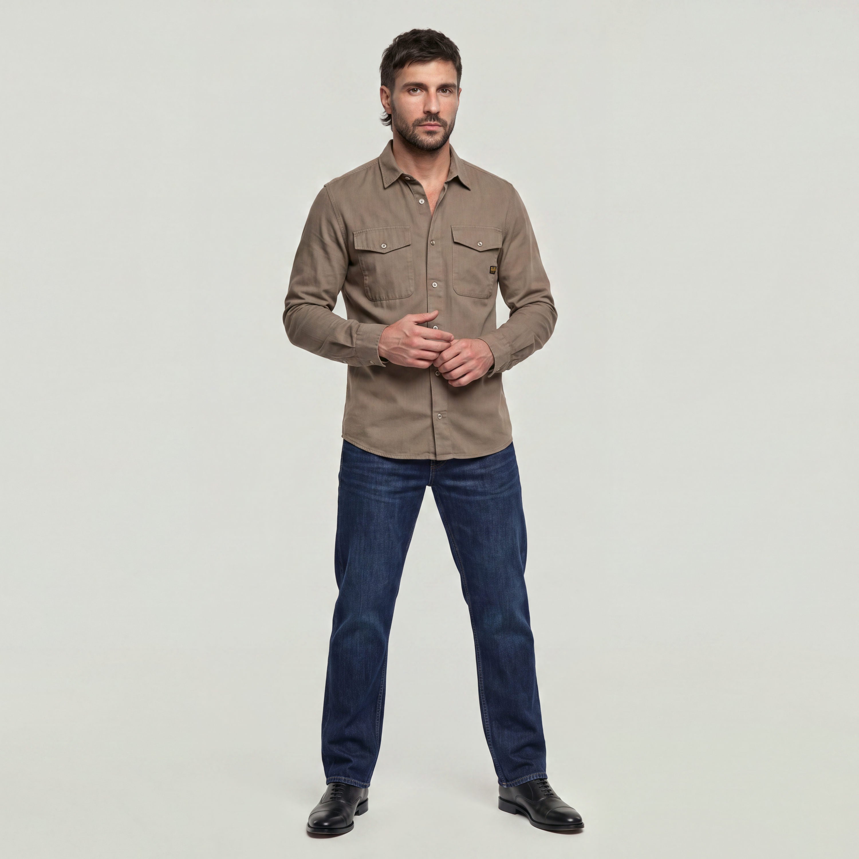 Model wearing a marine slim fit shirt with slim cut and chest pockets.