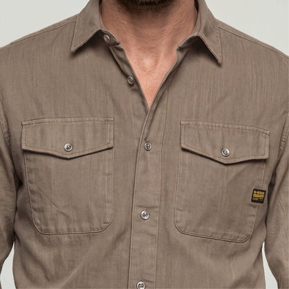 Marine slim fit shirt with button closure and chest pockets, showcasing a fitted design and rounded hem.