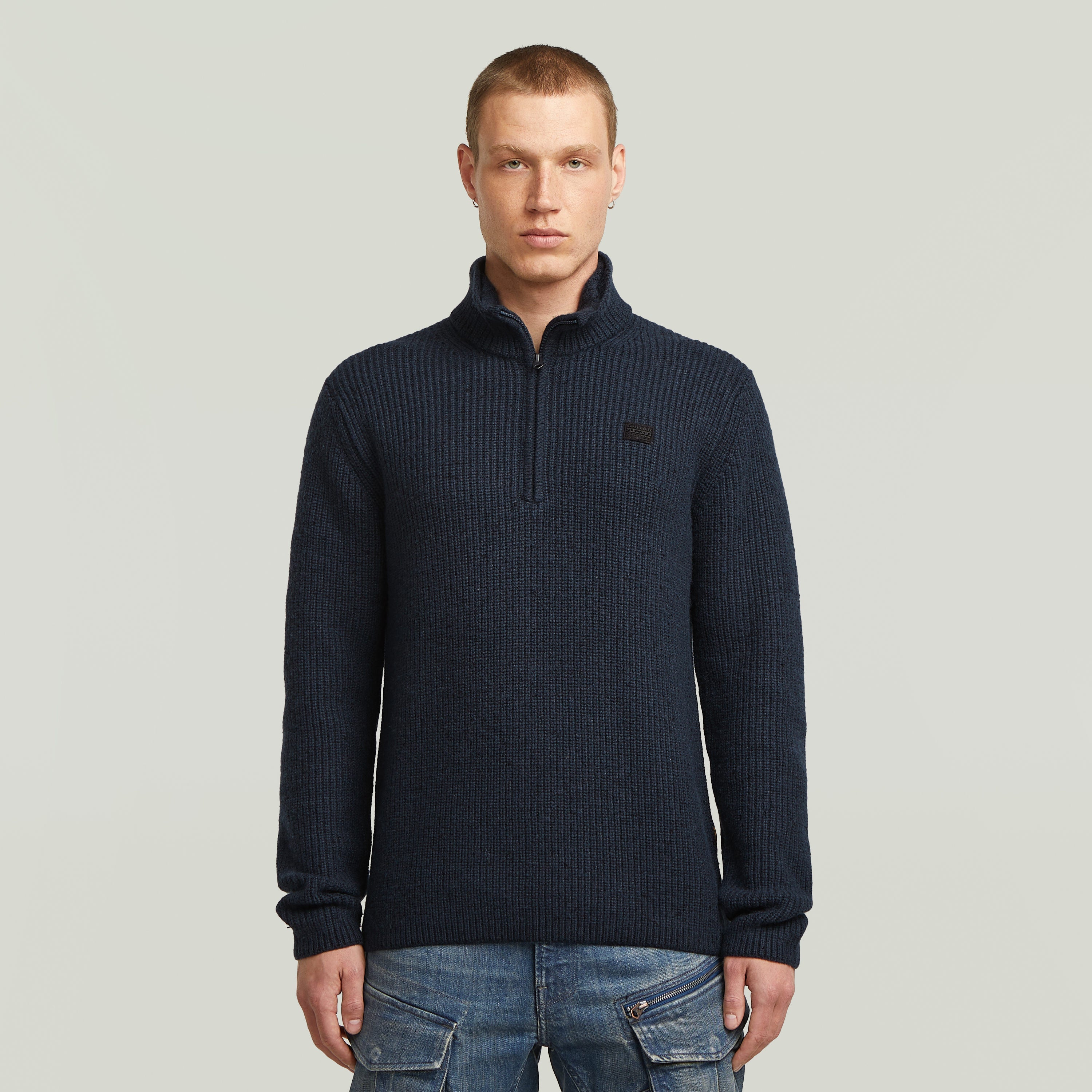 Double collar half zip knit sweater in navy worn by a model with short hair, stylish and functional design.