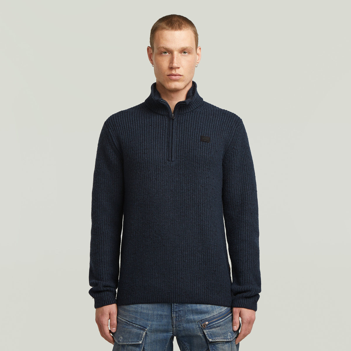 Double collar half zip knit sweater in navy worn by a model with short hair, stylish and functional design.