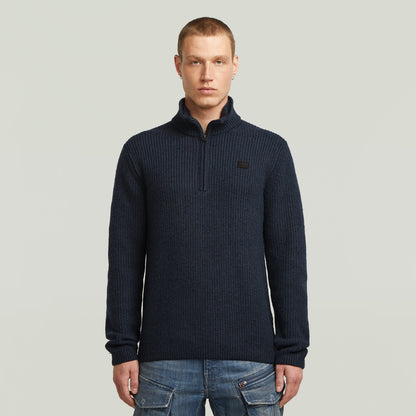 Double collar half zip knit sweater in navy worn by a model with short hair, stylish and functional design.
