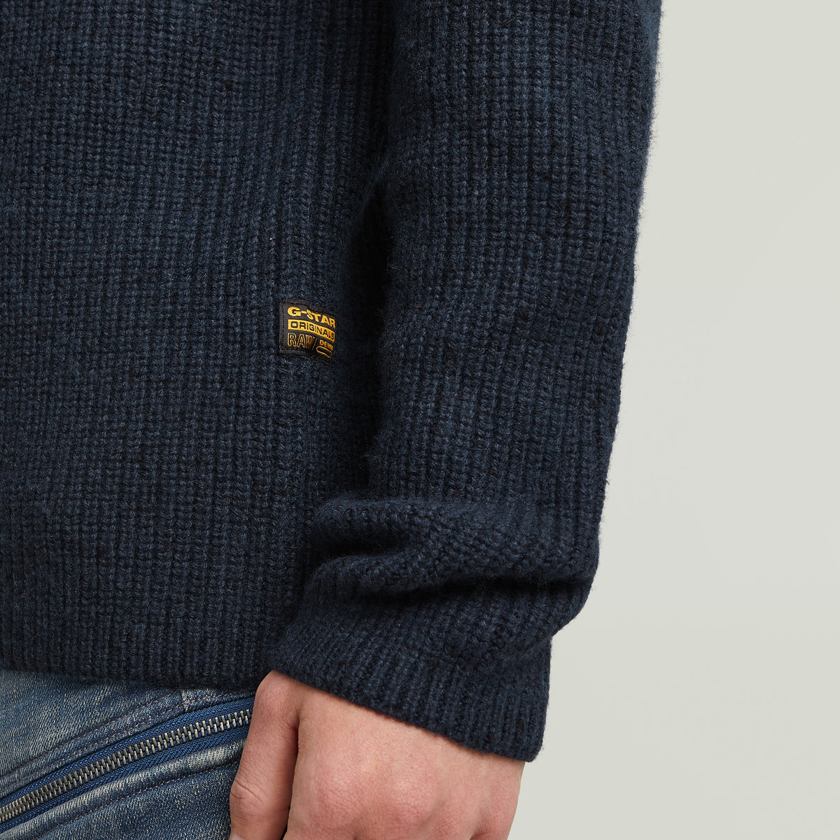 Detail of a double collar half zip knit sweater featuring ribbed texture and G-Star logo.