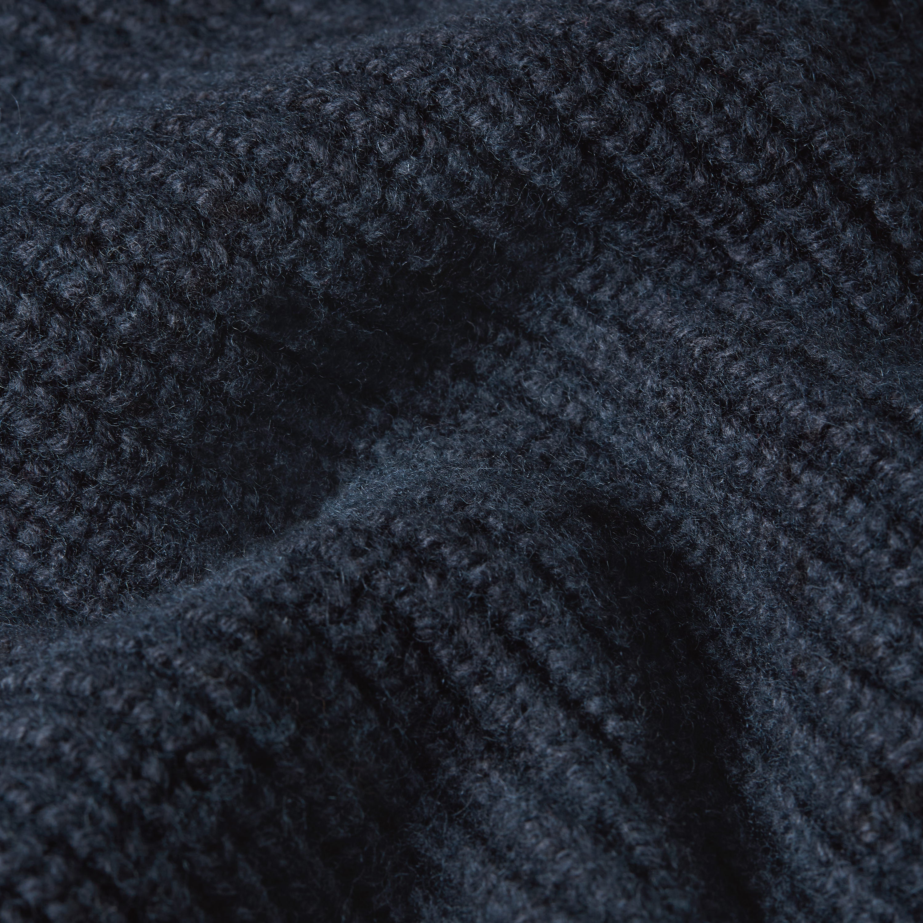 Close-up of fabric texture of a double collar half zip knit sweater in dark navy color.