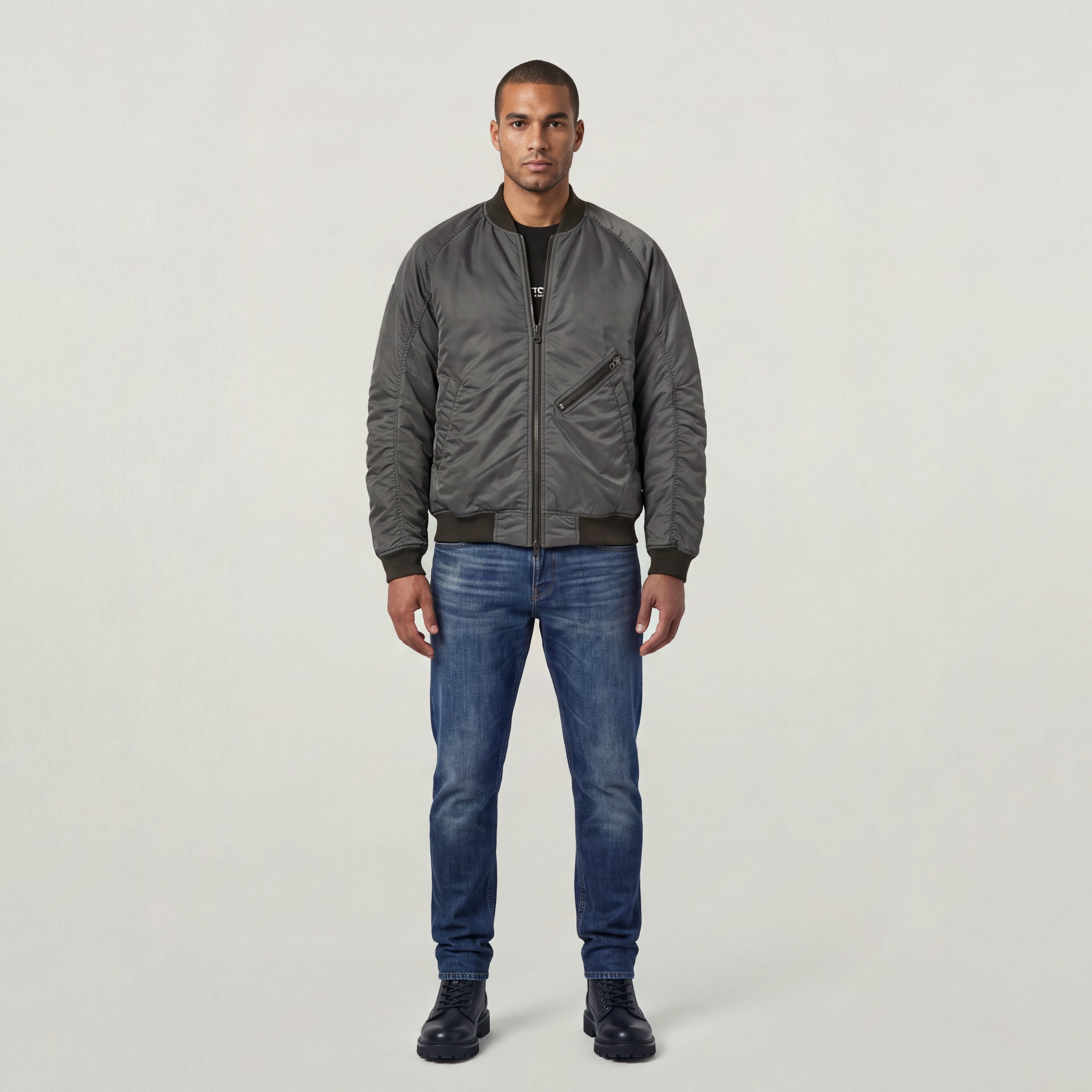 Model wearing GA-1 lightweight padded bomber jacket with jeans and boots against a light background.