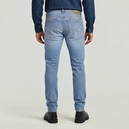 Hombre usando jeans de corte slim moderno, vista trasera en color claro, slim tapered jeans for men.