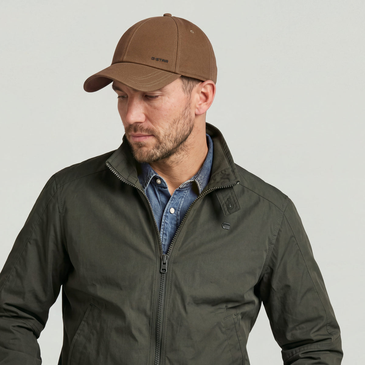 Avernus baseball cap worn by a man in a green jacket and denim shirt, showcasing its classic design.