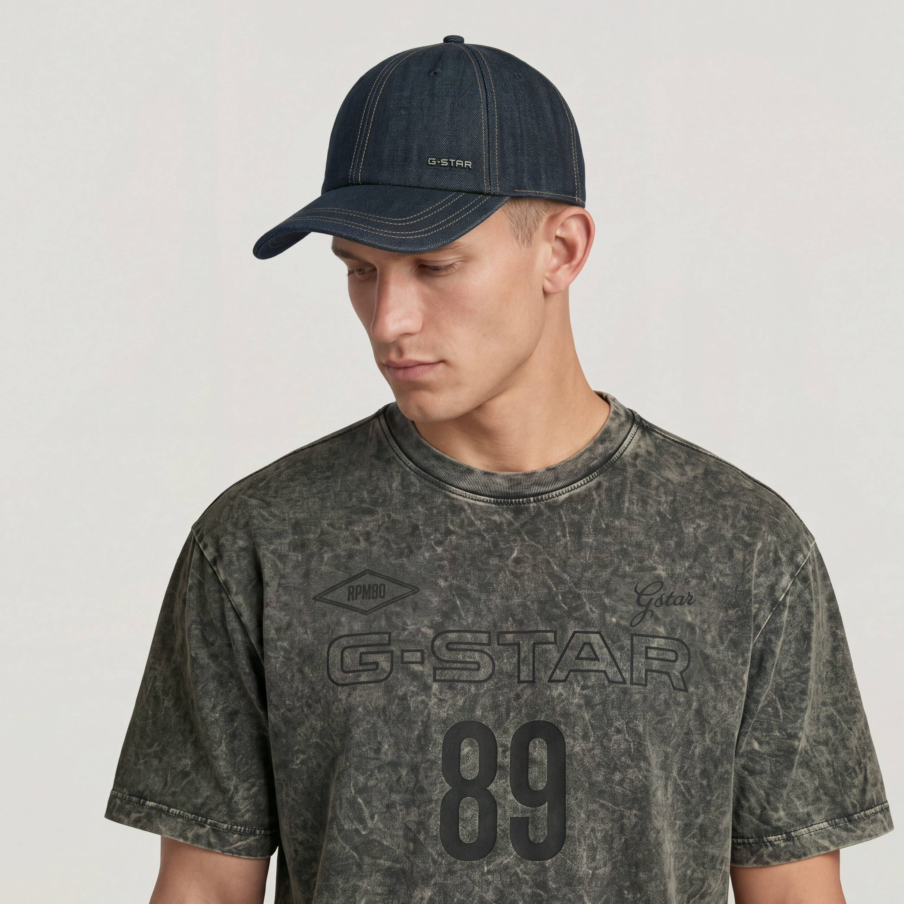 Avernus baseball cap with adjustable clip worn by model, featuring G-STAR logo and stylish denim design.