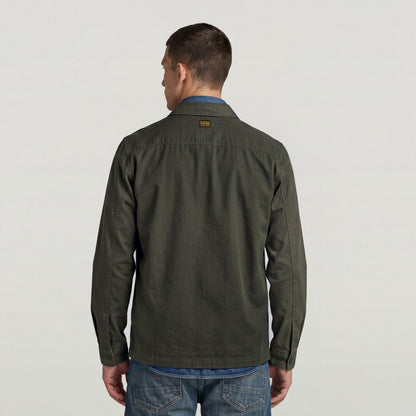 Back view of a model wearing a classic lightweight overshirt in dark green with a casual look.