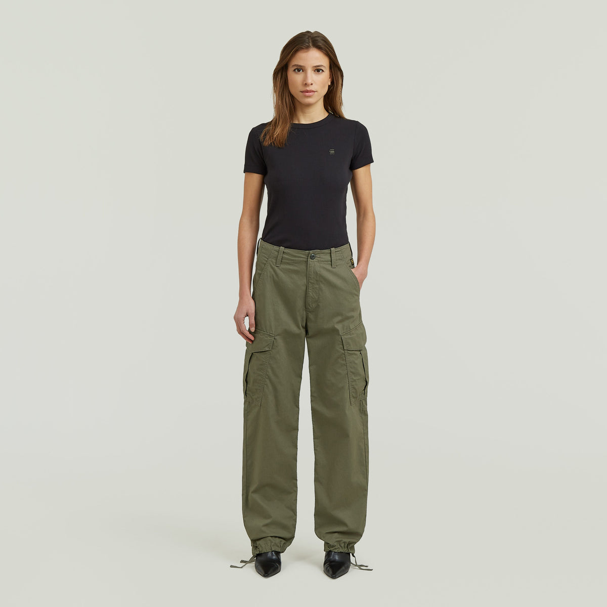 Mujer vistiendo Holt Cargo Pants, mostrando pantalones loose fit cargo pants en color oliva.