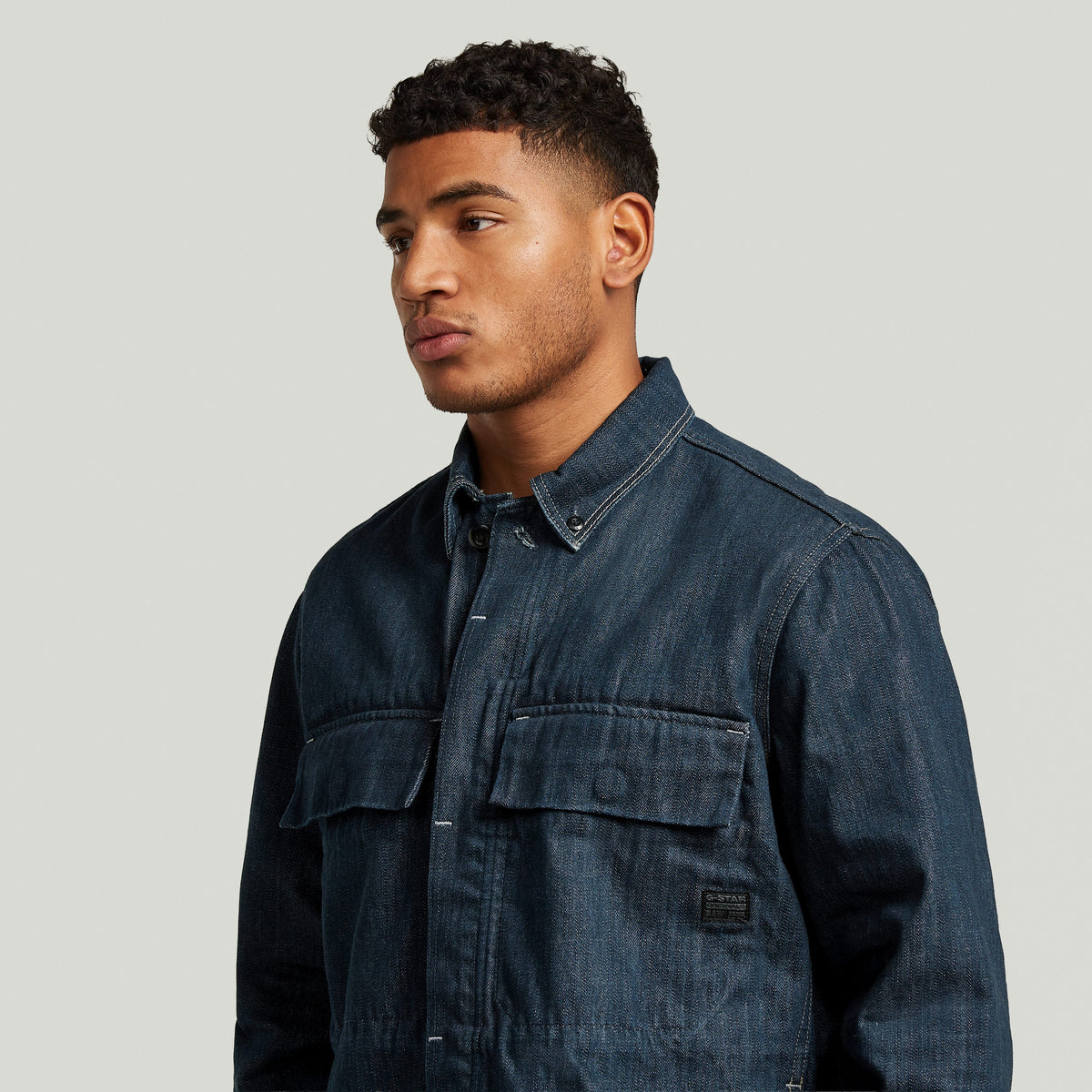 Model showcasing the Boxy Clean denim overshirt with chest pockets and button closure.