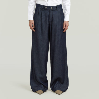 Model wearing pleated chino pants, showcasing a classic straight cut and modern design.