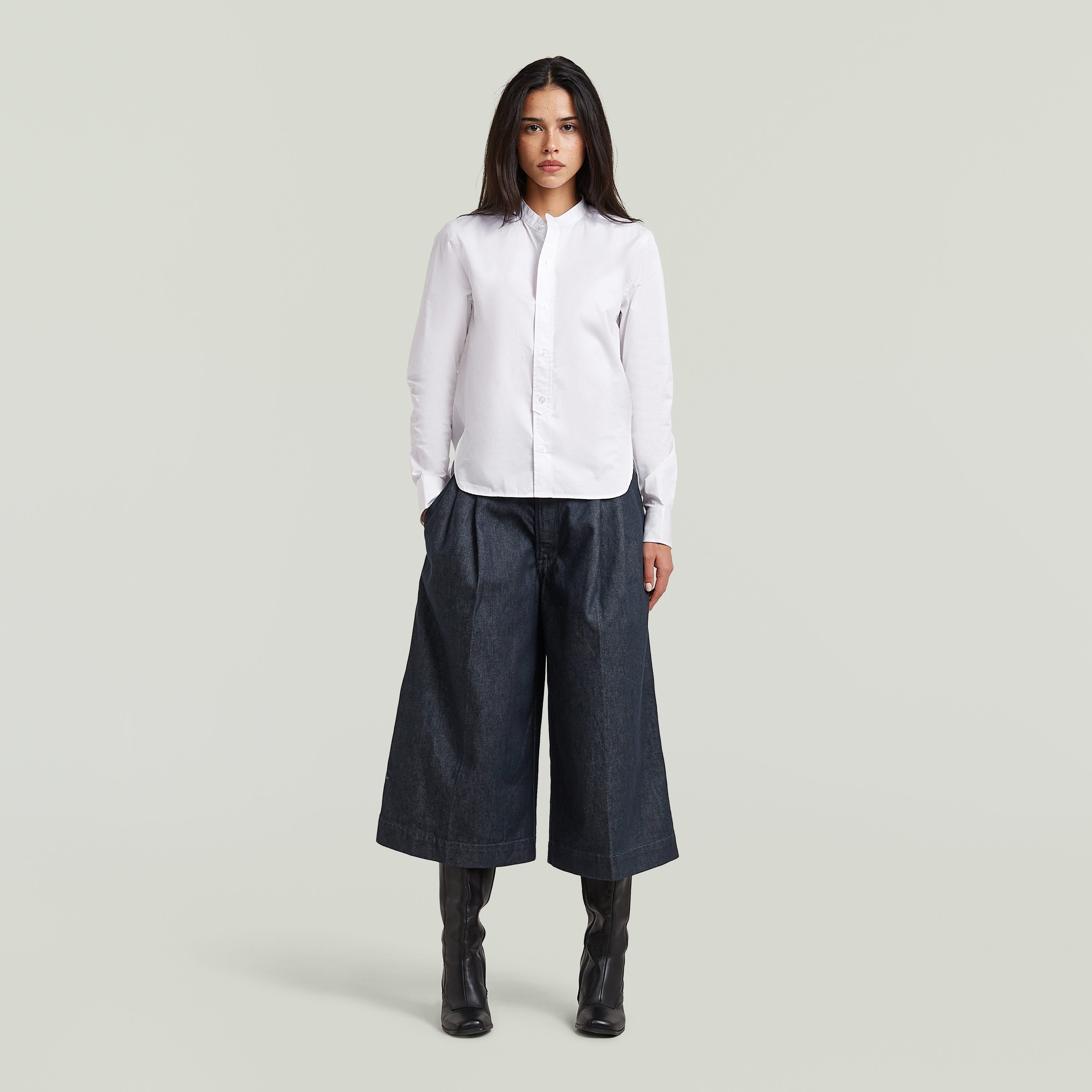 Model wearing a classic button-up long sleeve shirt paired with wide-leg pants.