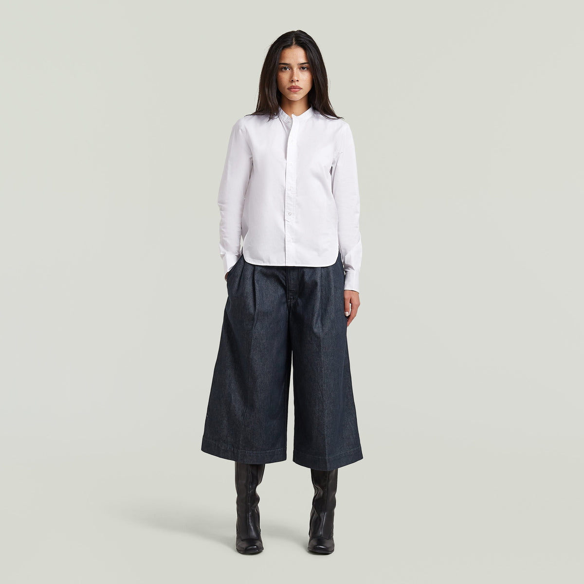 Model wearing a classic button-up long sleeve shirt paired with wide-leg pants.