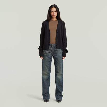 Mujer que lleva un cárdigan entallado cuello V con cierre de corchetes y jeans.