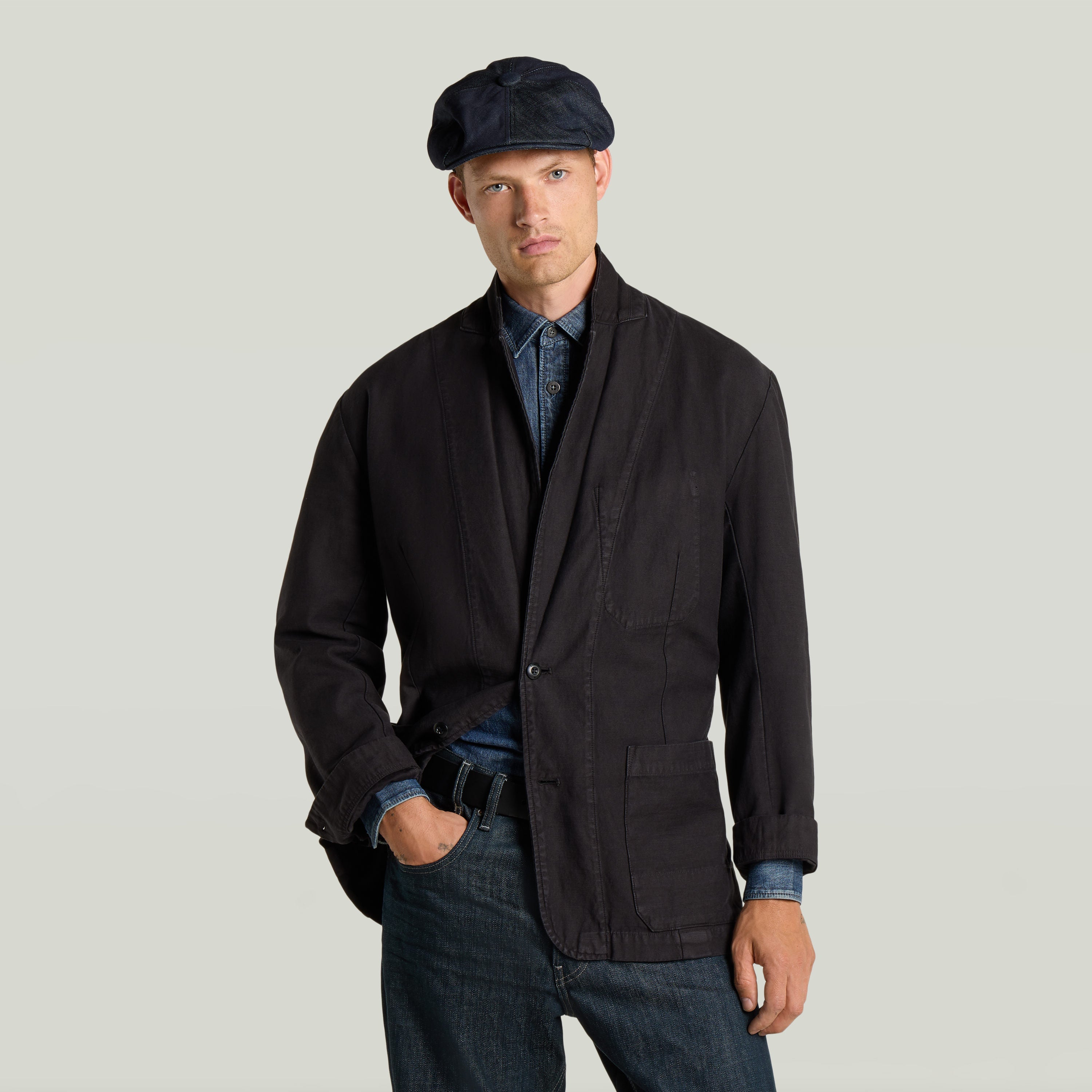 Casual sport blazer worn by a man with a cap, featuring a loose fit and classic lapel design.