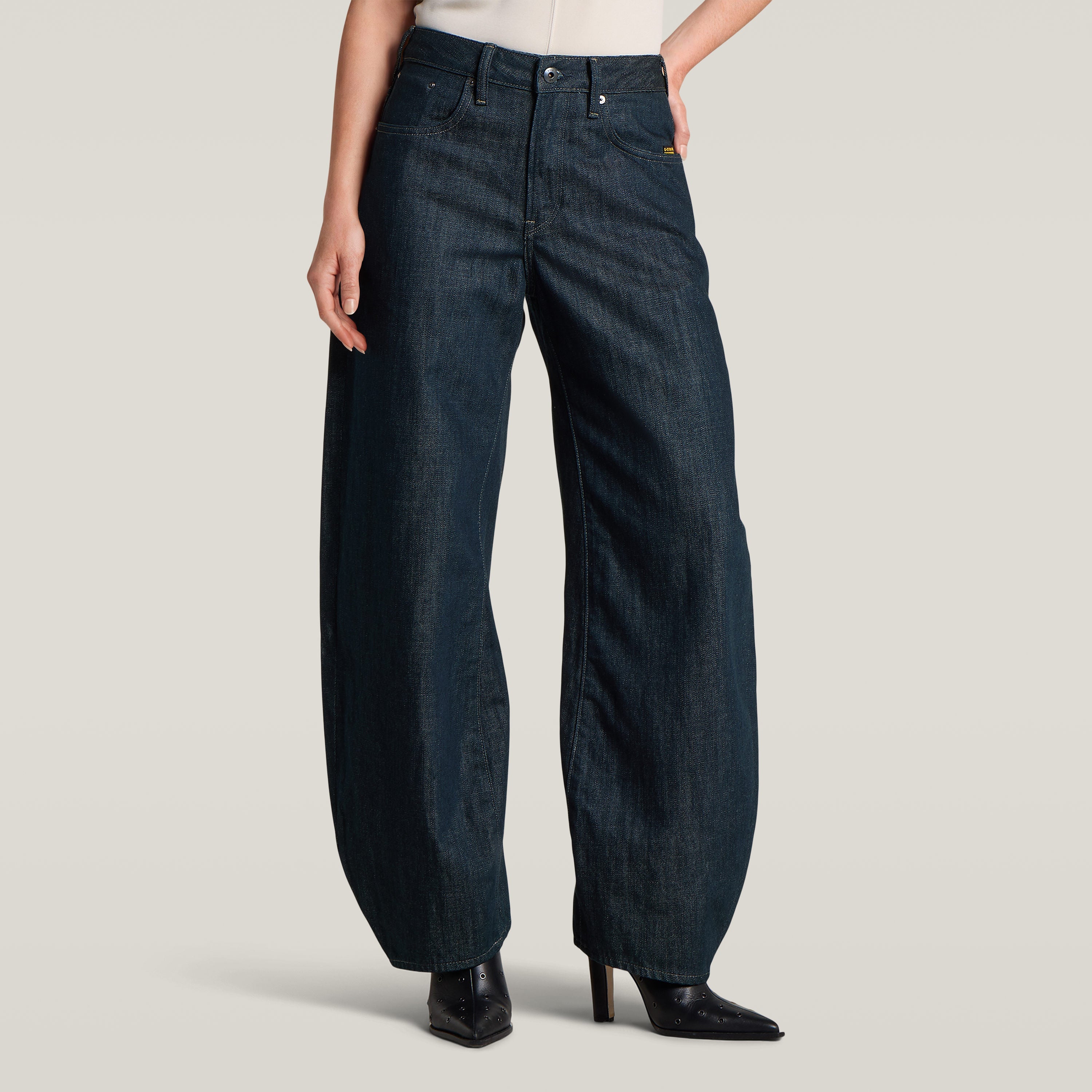 Mujer usando jeans Barrel 3D Loose, de corte holgado y alta cintura, en fondo beige.
