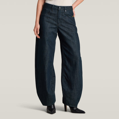Mujer usando jeans Barrel 3D Loose, de corte holgado y alta cintura, en fondo beige.