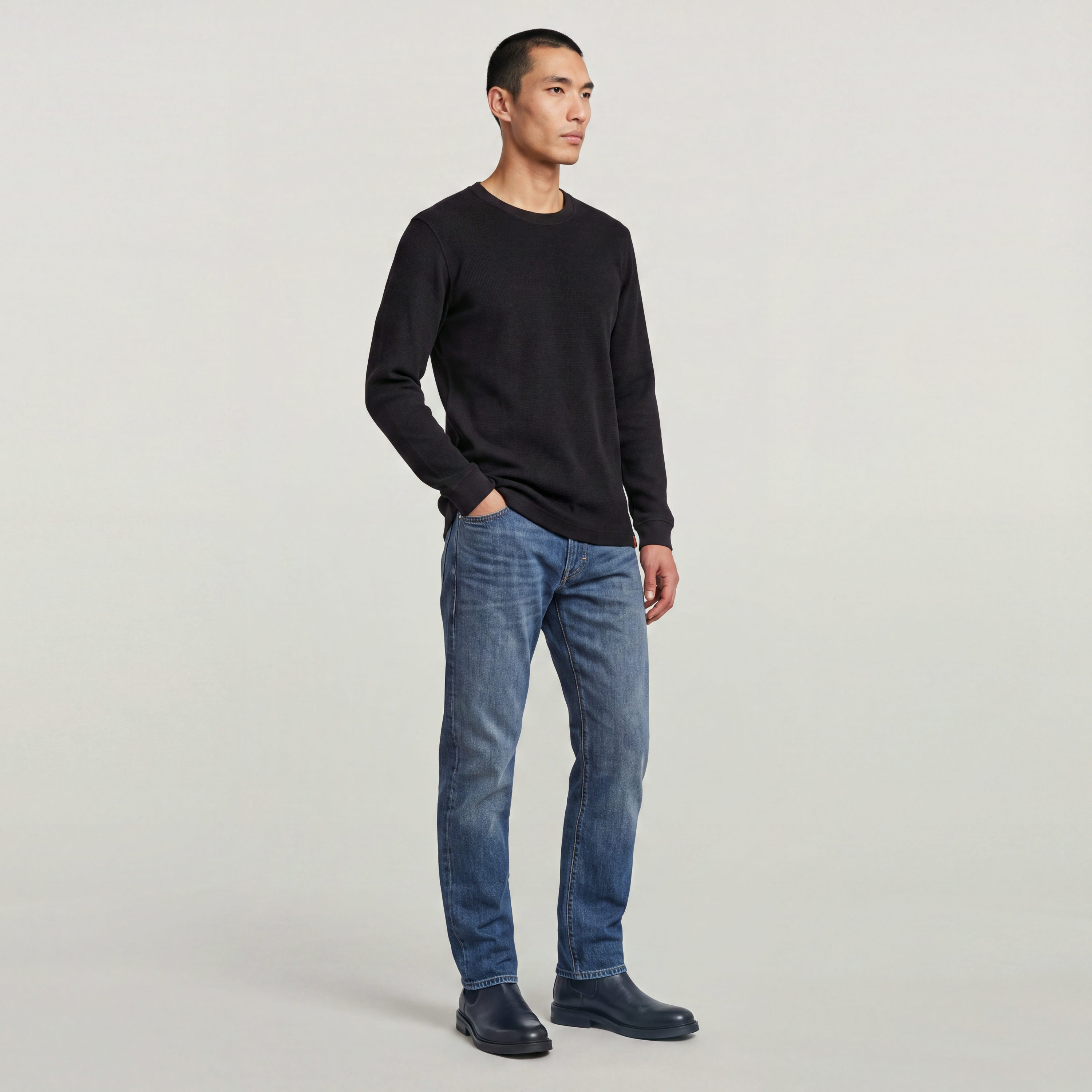 Modelo masculino vistiendo camiseta Tweeter Brushed de algodón cepillado y jeans en un fondo neutro.