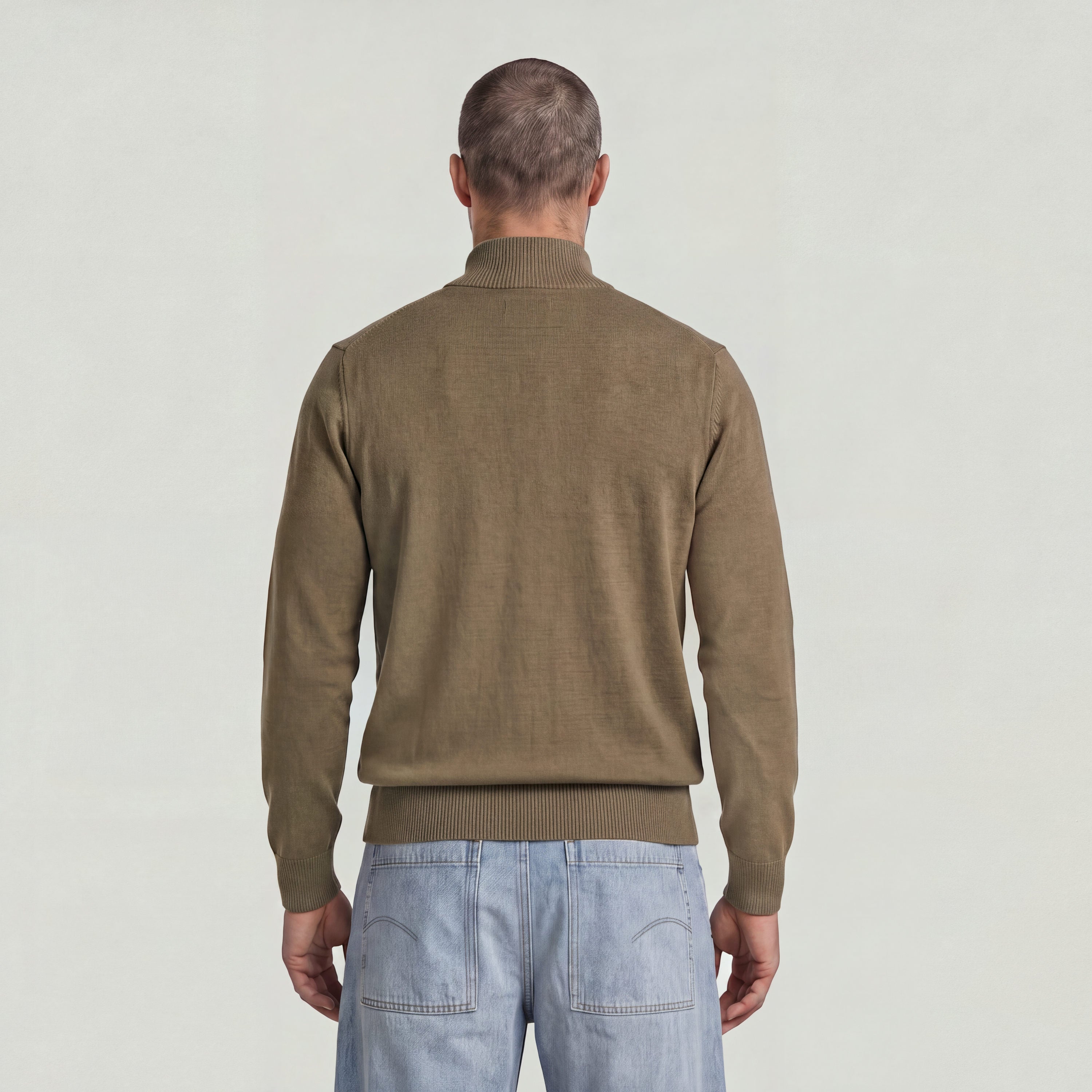 Back view of a man wearing the Core Refined Half Zip Knit sweater in olive green.