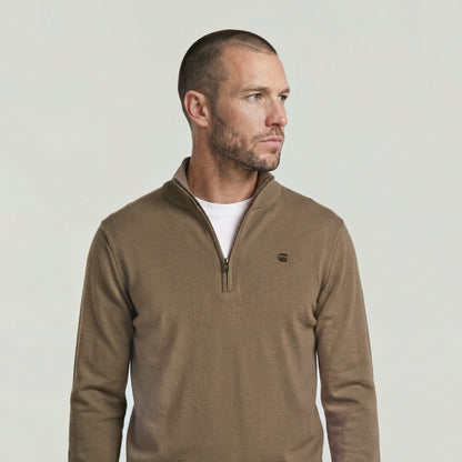 Elegante suéter de punto half zip knit sweater con cuello alzado, cierre de media cremallera, y diseño moderno.