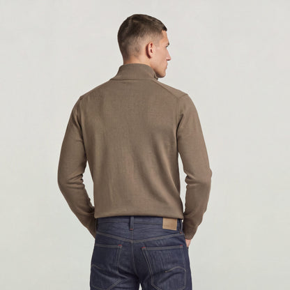 Back view of a model wearing the core refined full zip knit in a stylish brown color.