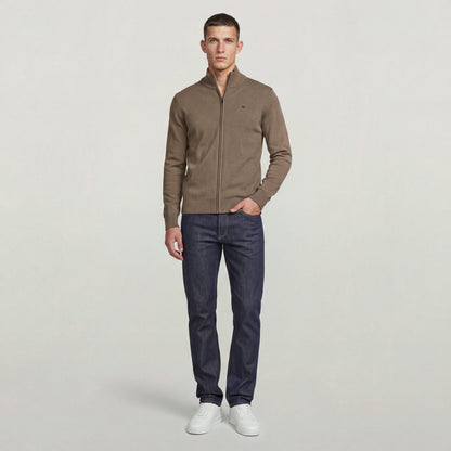 Hombre usando el Core Refined Full Zip Knit en color marrón con jeans oscuros y zapatillas blancas.