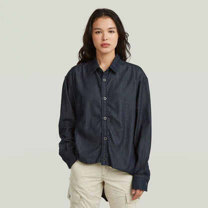 Model wearing a lightweight relaxed shirt in dark denim, featuring a classic collar and button closure.