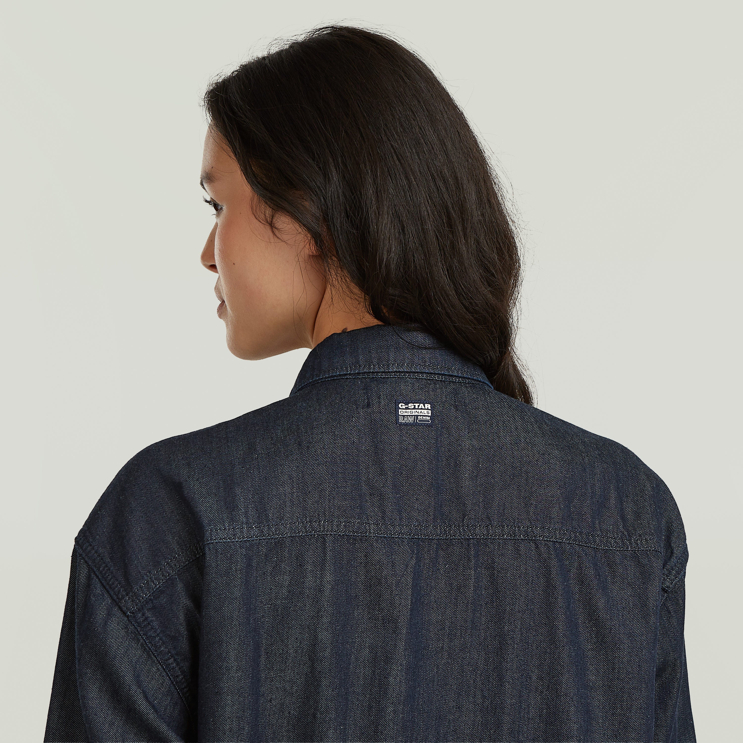 Mujer usando una camisa ligera Tucked-In Relaxed con diseño clásico y cómodo, vista desde atrás.