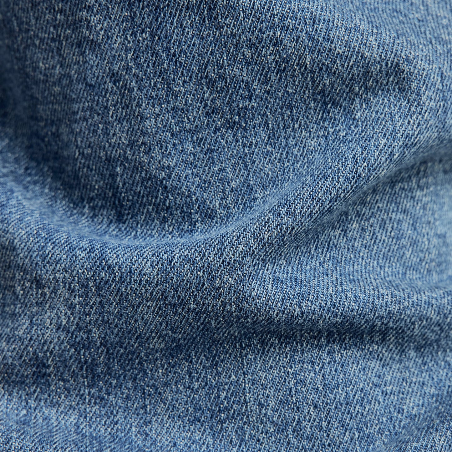 G-Star 3301 slim jeans denim fabric texture close-up, showcasing medium indigo color and detailed weave.