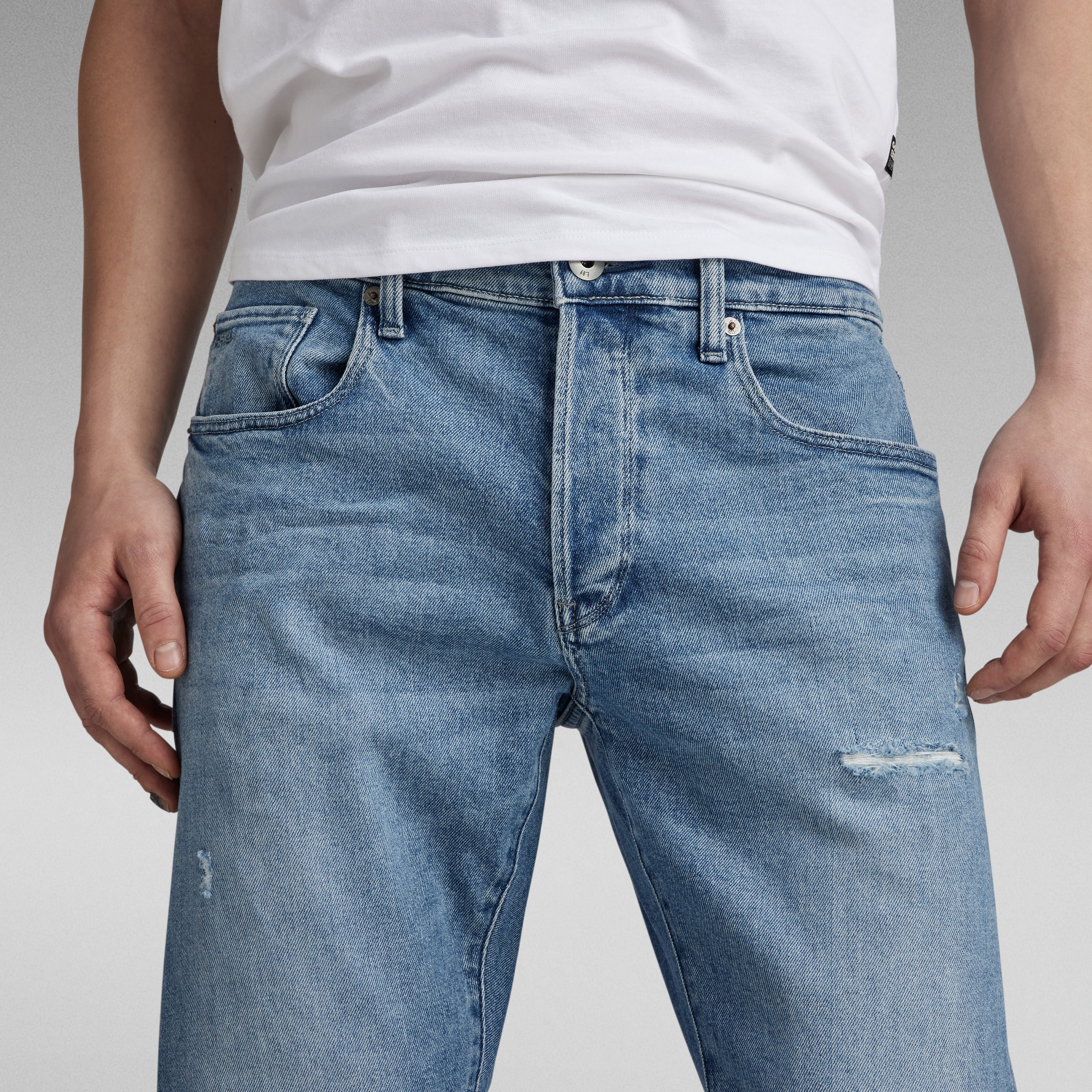 G-Star 3301 slim jeans worn by a model, showcasing the classic five-pocket design and button fly.