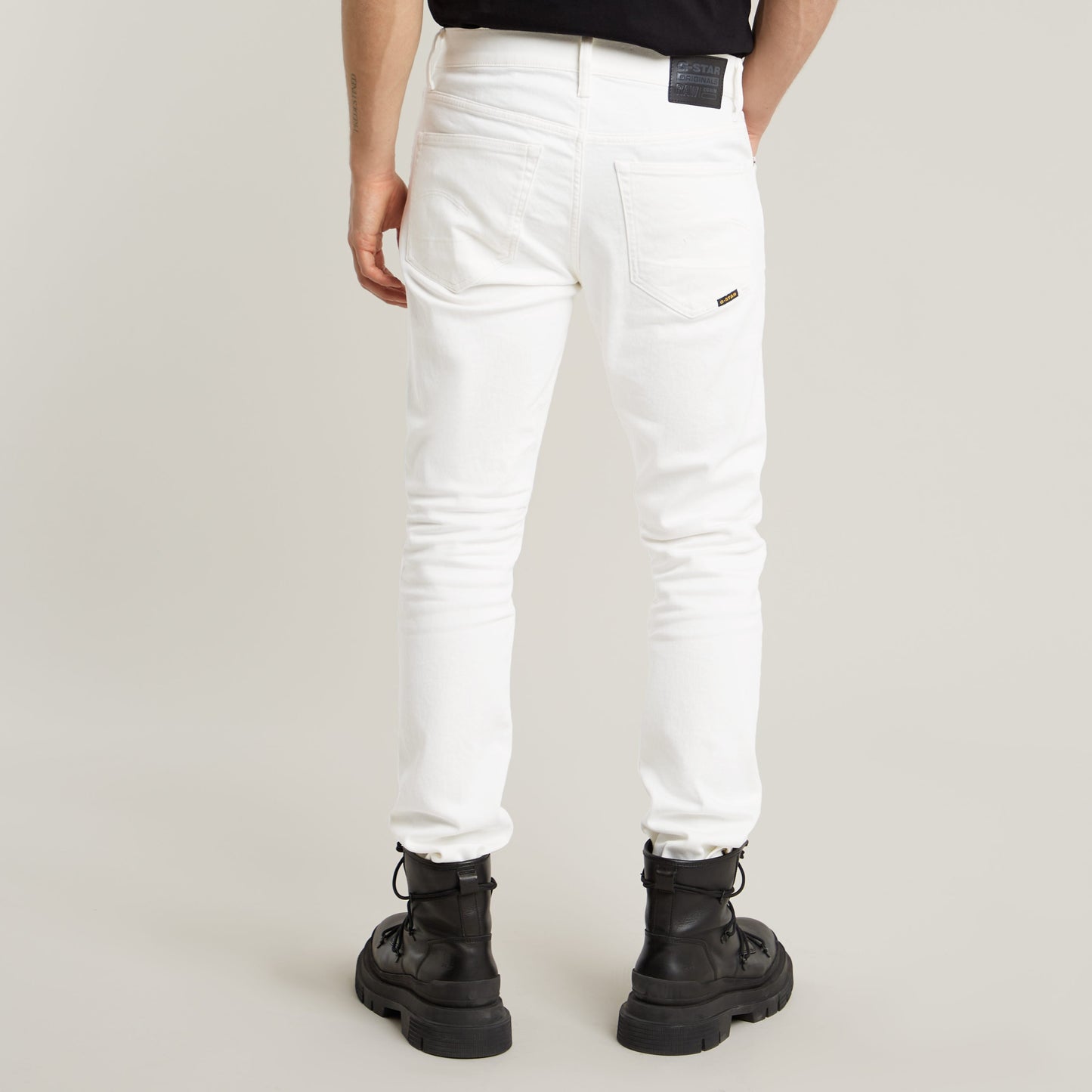 Vista trasera de los jeans G-Star 3301 Slim en color blanco, combinados con botas negras.
