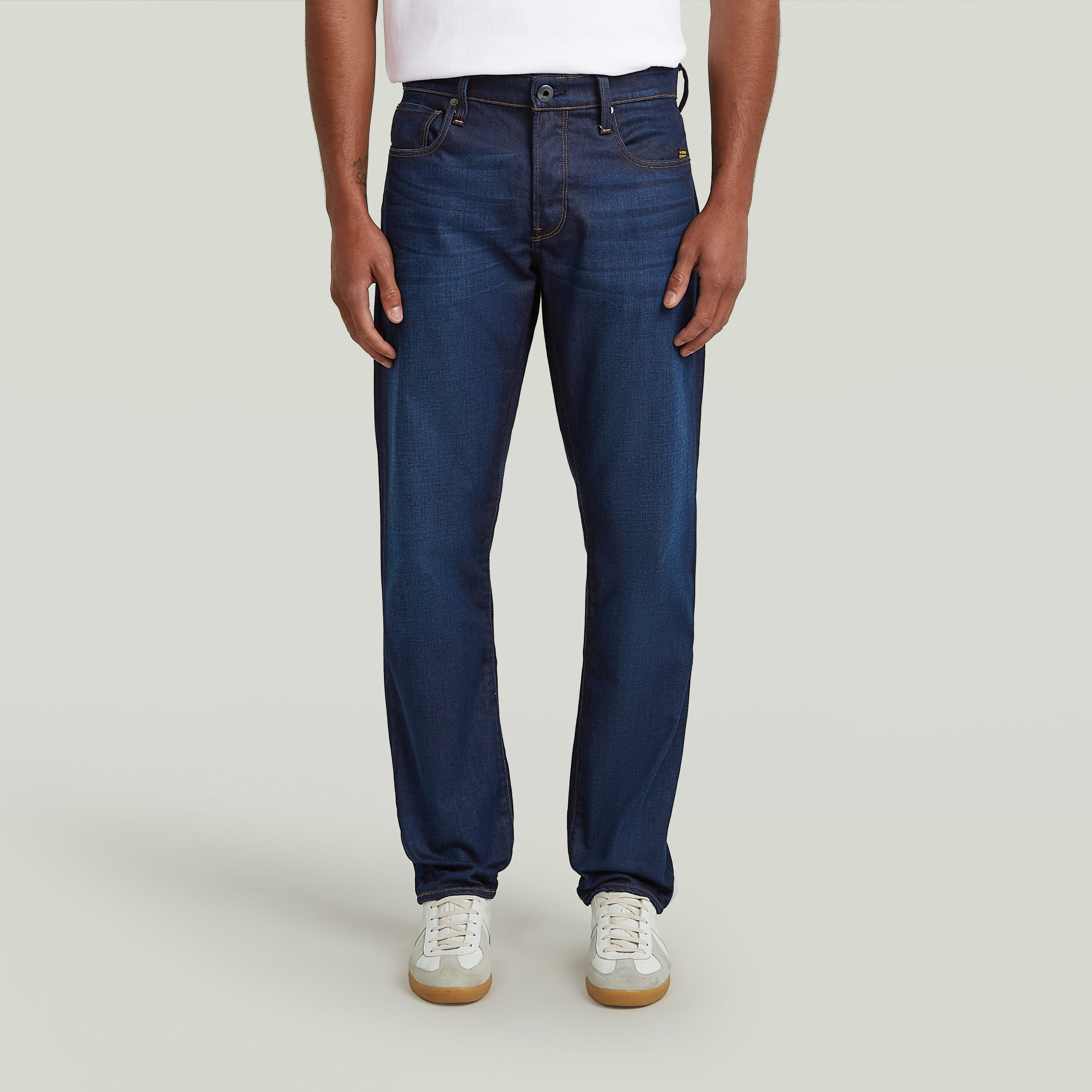 Modelo usando G-Star 3301 Straight jeans de color índigo con camiseta blanca y zapatillas deportivas.