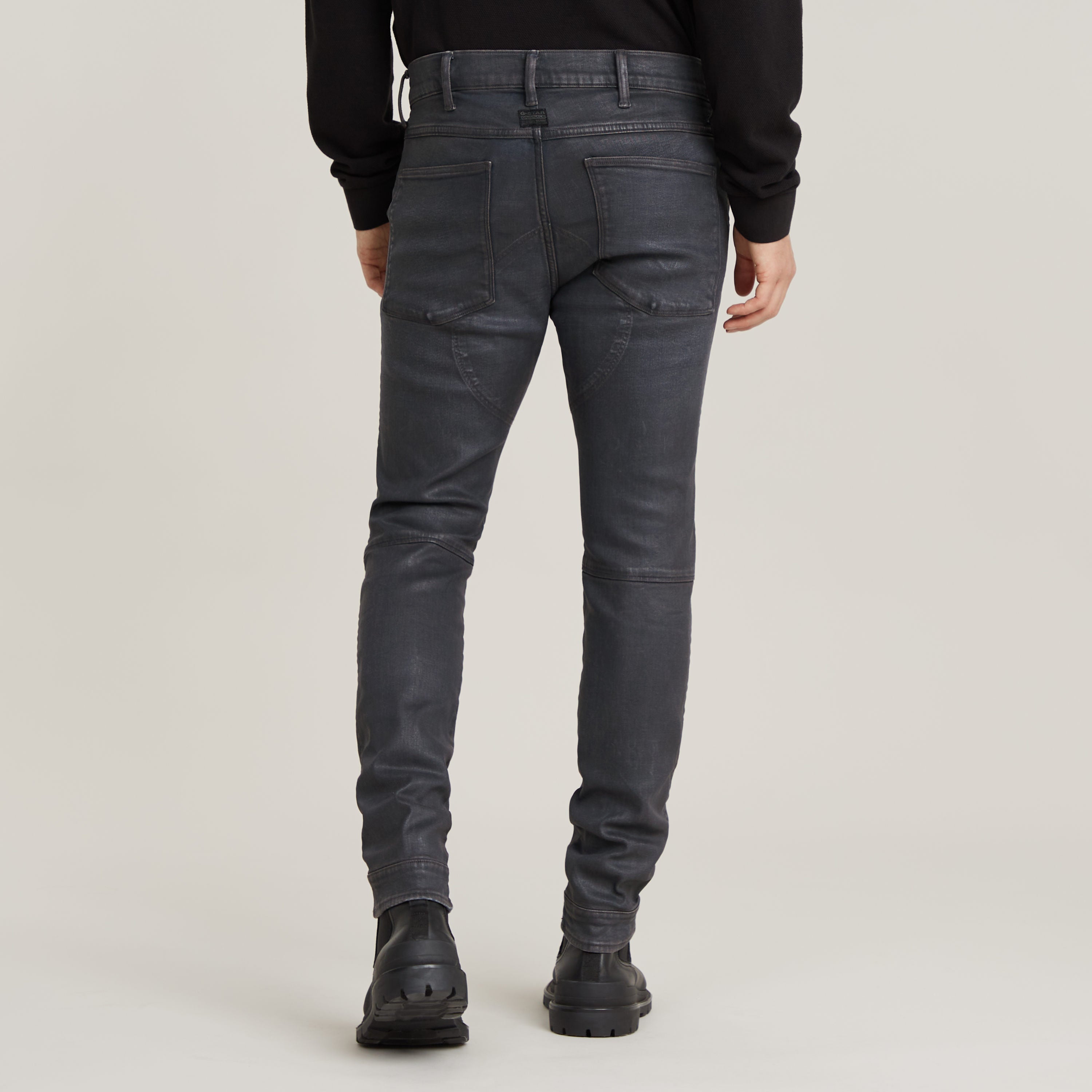 3D zip knee skinny jeans displayed from the back, showcasing detailed stitching and pocket design.