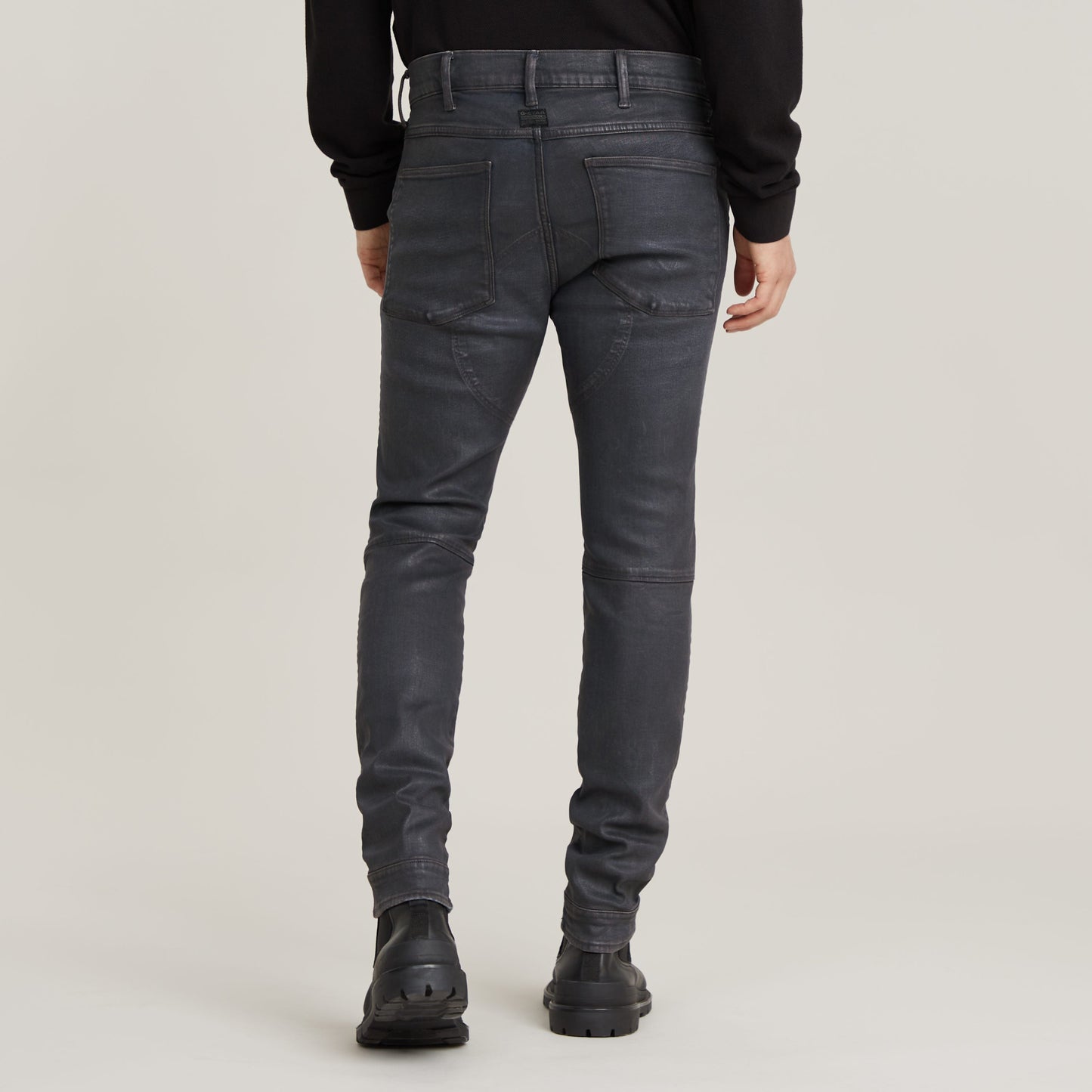 3D zip knee skinny jeans displayed from the back, showcasing detailed stitching and pocket design.