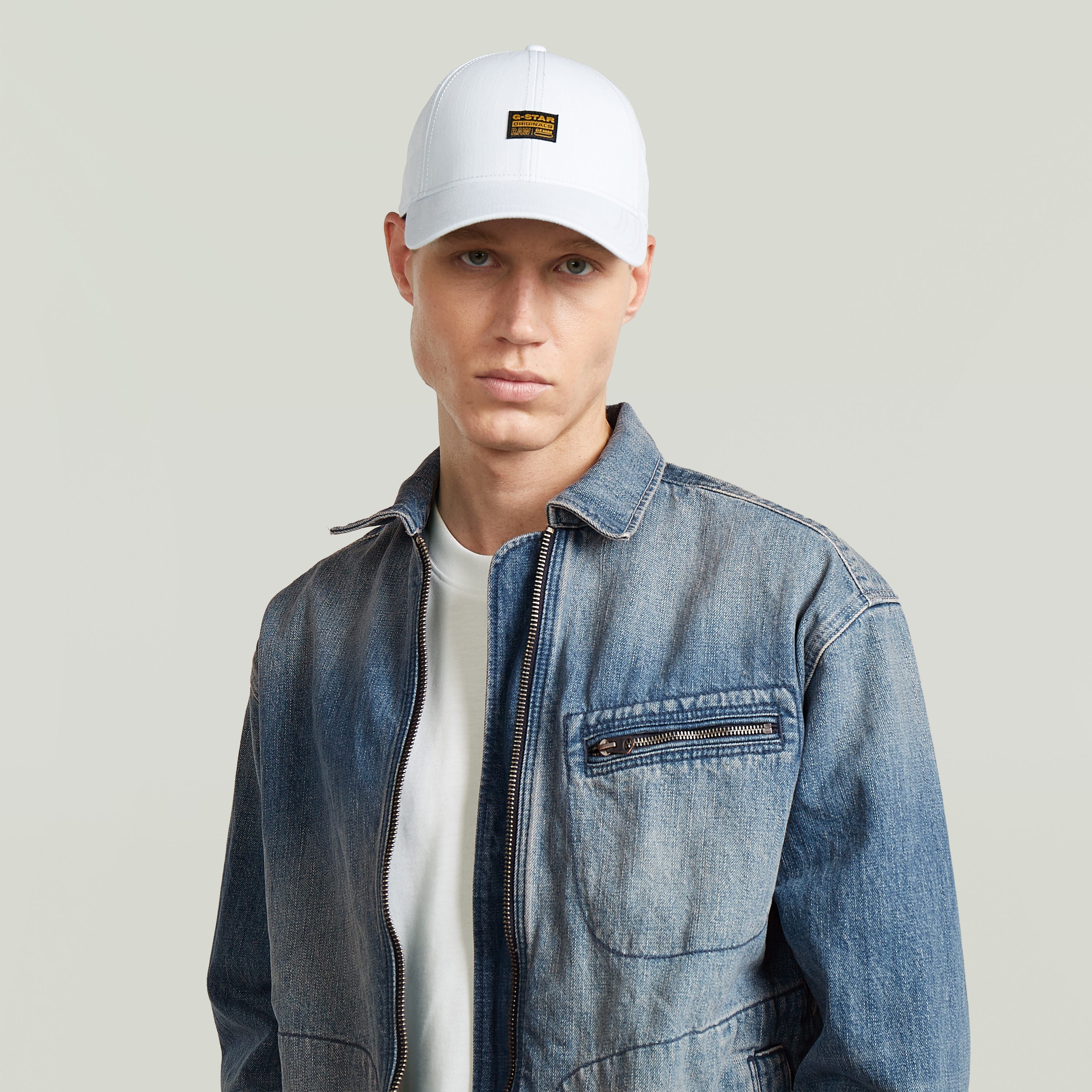 Hombre vistiendo la gorra Originals Baseball ajustable con chaqueta de mezclilla.