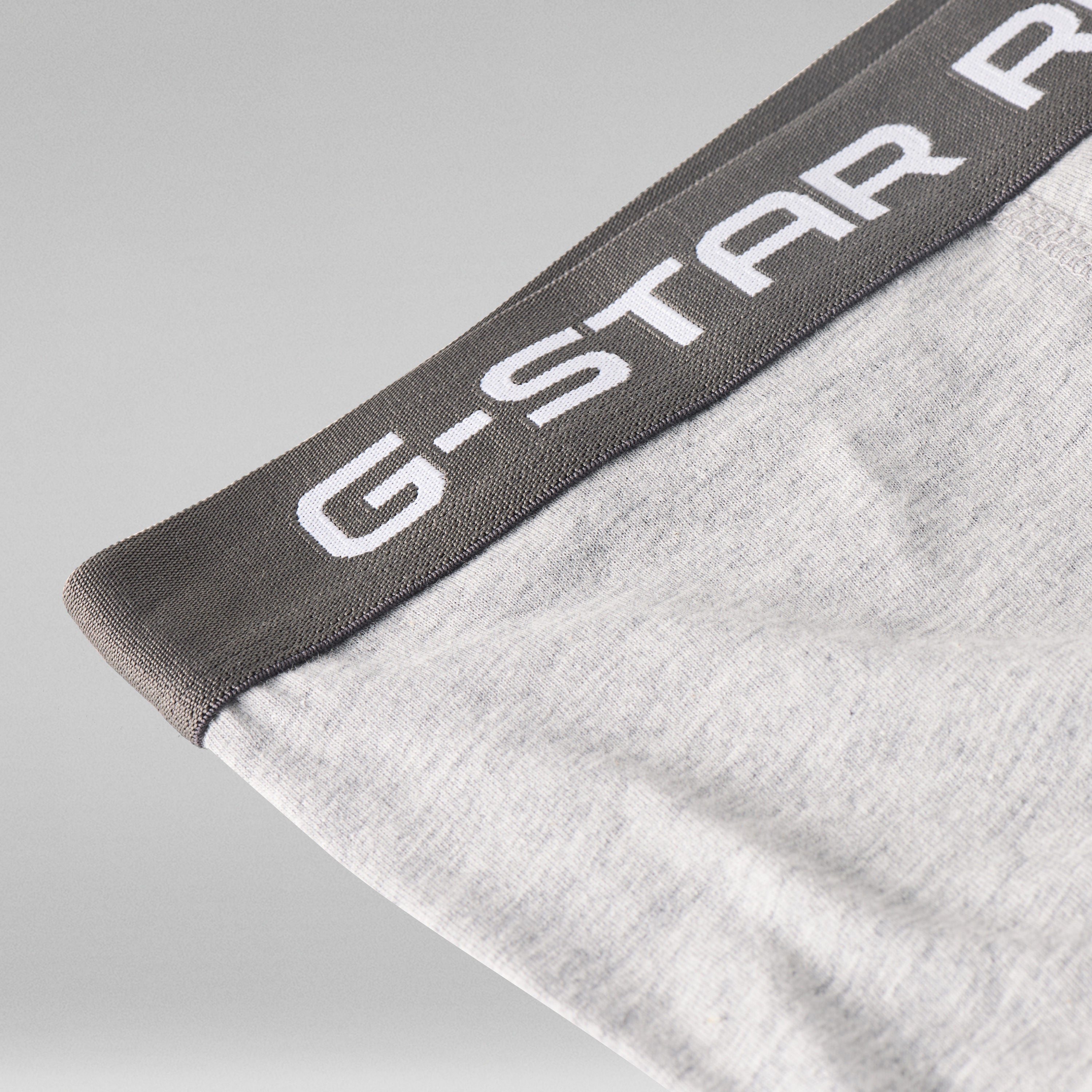 Cinturilla de los clásicos bóxers G Star en gris con logotipo en blanco sobre fondo gris claro.
