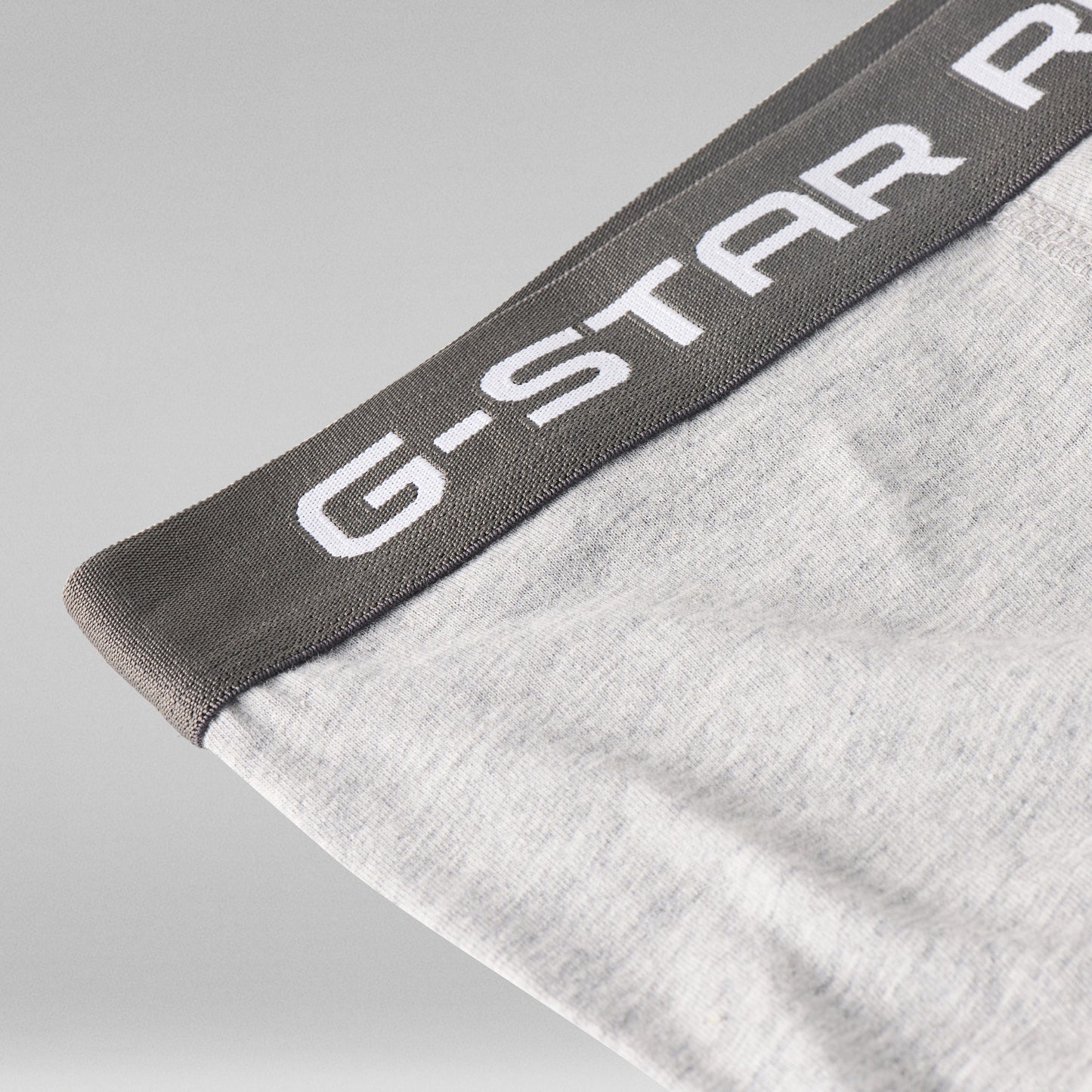 Cinturilla de los clásicos bóxers G Star en gris con logotipo en blanco sobre fondo gris claro.