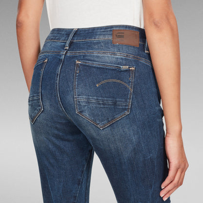 Mujer usando jeans Arc Skinny, vista trasera que destaca el diseño y la etiqueta del logotipo en la cintura.