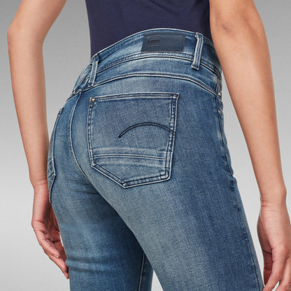 Detrás de una mujer usando jeans Lynn skinny fit jeans en denim azul claro, mostrando detalles de los bolsillos.