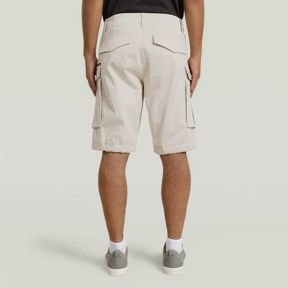 Back view of relaxed fit zip shorts in beige, featuring multiple pockets and a comfortable design.