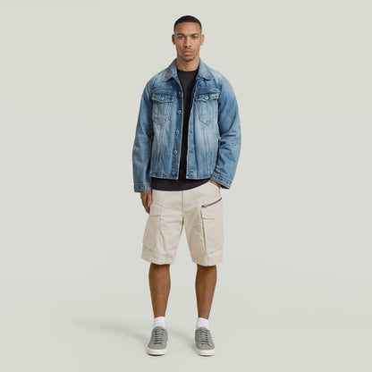 Model wearing relaxed fit zip shorts with a denim jacket and sneakers on a neutral background.